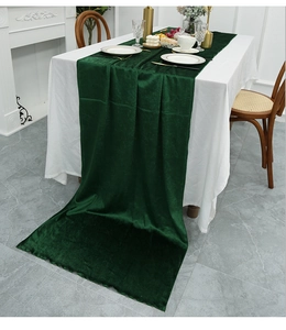 Detailed view of dark green velvet table runner with elegant wavy edges and thick texture