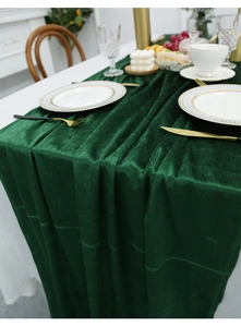 Dark green velvet table runner on white table with elegant dinnerware set
