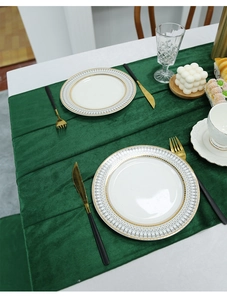 Close-up of a dark green velvet table runner styled with elegant dinnerware