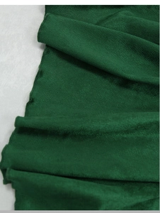 Close-up of deep green velvet table runner showing high-quality edge stitching and texture