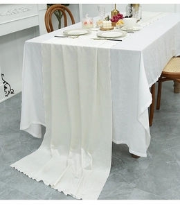 Detail of ivory velvet table runner with elegant wave edges for Nordic dining decor