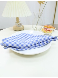 Close-up of blue and white checkered cotton linen napkin on a white ceramic plate