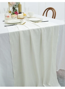 Detail view of cream velvet table runner with fine stitching and soft drape on a table