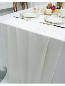 Elegant white velvet table runner with gold cutlery on a luxury minimalist dining set