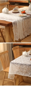 Détail d'une nappe en dentelle blanche avec motif floral ajouré et bords festonnés