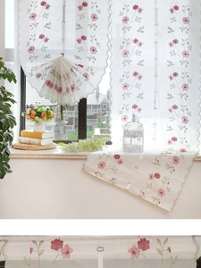 Détail de broderie marguerite et bord festonné sur store romain semi-transparent