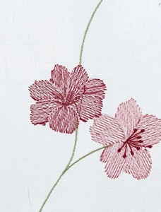 Gros plan d'une broderie de marguerite rouge sur un voilage en dentelle blanche