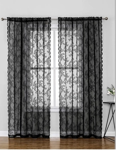 Detail of black lace curtain with rose floral embroidery and scalloped wave edges