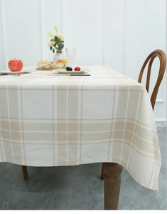 Detail of Nordic plaid linen tablecloth with elegant drape on a wooden dining table