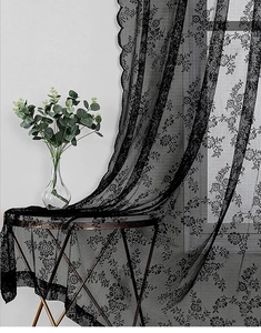 Close-up of black floral lace curtain fabric with elegant scalloped wave edge detail