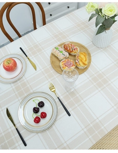 Close-up of beige plaid linen tablecloth showing fabric texture and elegant drape