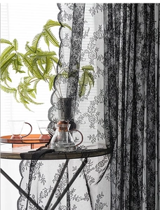 Detail of black lace curtain with rose floral patterns and elegant scalloped wavy edges