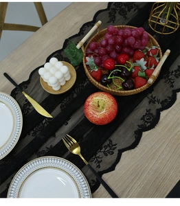 Elegant black lace table runner featuring delicate floral embroidery and scalloped edges