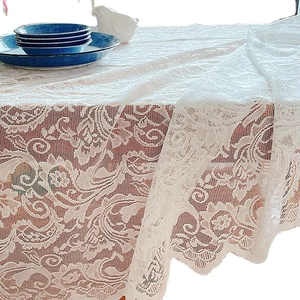 Nappe élégante en dentelle blanche avec motifs floraux et bords ondulés pour la table