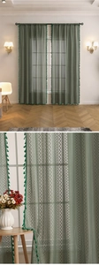 Détail du rideau en dentelle vert foncé avec motifs de vagues et bordures à glands