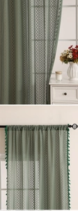 Détail du rideau en dentelle géométrique vert foncé avec glands décoratifs et tissage texturé