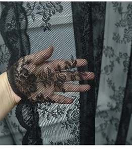 Détail du tissu en dentelle noire semi-transparente avec broderie florale pour rideaux