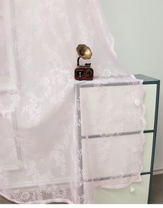 Gros plan du rideau en dentelle rose clair avec des motifs floraux au crochet délicats