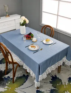 Close-up of blue rectangular tablecloth featuring exquisite white lace edge on wood table