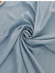 Detail of misty blue table cloth with fine texture and subtle shimmer folds