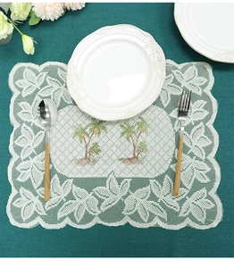 Detailed shot of rectangular white lace placemat featuring tropical coconut tree patterns