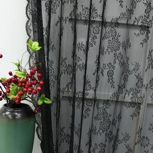 Vintage black floral lace curtain featuring delicate rose patterns and scalloped edges