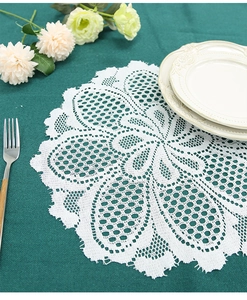 Close-up of white lace placemat with intricate floral patterns and scalloped edges