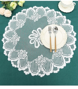 Detailed top view of white lace round placemat with intricate crochet floral patterns
