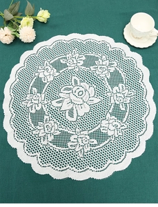 Macro view of white round lace placemat featuring intricate rose patterns and scalloped edges