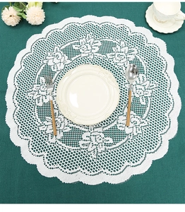 Detailed top view of white lace round placemat with intricate hollow embroidery