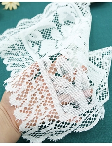 Close-up of intricate white lace pattern and hollow floral weaving detail