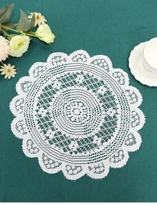 Close-up of white round crochet lace placemat with elegant scalloped petal edges