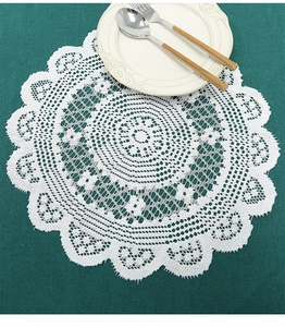 Macro detail of white round lace placemat with hollow weaving and wavy edges on a table