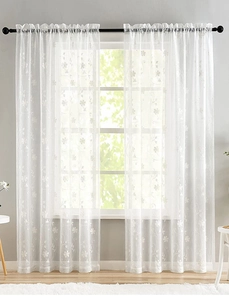Detailed close-up of white sheer lace curtains with elegant floral embroidery patterns