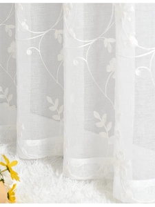 Close-up of white milk silk sheer curtain with delicate floral embroidery details