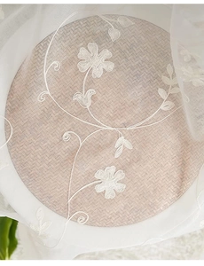Detailed embroidery of white floral patterns on elegant sheer lace curtain fabric