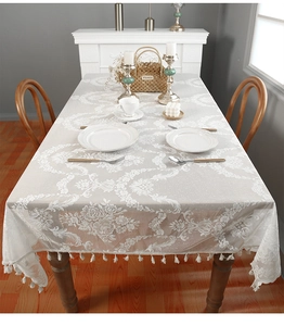 Detail of French romantic lace tablecloth with floral patterns and tassel trim