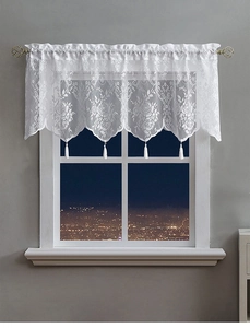 Close-up of white lace curtain with floral embroidery and elegant hanging tassels