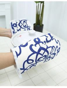 Close-up of thick Nordic blue patterned oven mitt and pot holder set protecting hands
