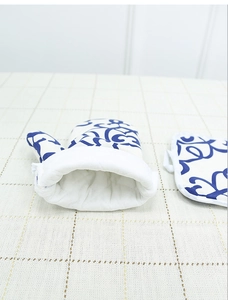 Detailed view of insulated oven mitt and pot holder with blue floral patterns on cotton