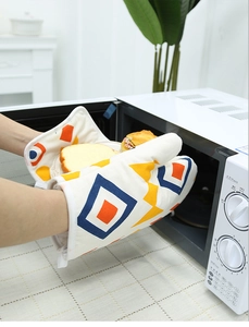 Nordic geometric oven mitt protecting hands while removing hot food from microwave