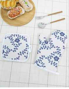 Detail of Nordic style oven mitt and potholder set with blue floral pattern on table