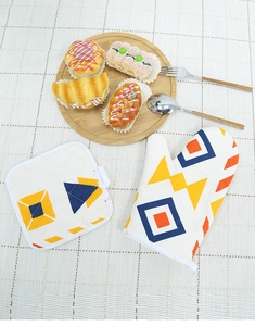 Detail of Nordic kitchen oven mitt and heat-resistant mat with colorful geometric patterns