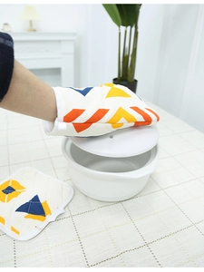Close-up of heat-resistant Nordic oven mitt lifting a lid over a cotton pot holder
