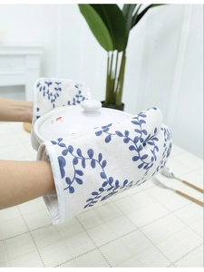 Close-up of Nordic style oven mitt showing thick cotton fabric and blue leaf pattern