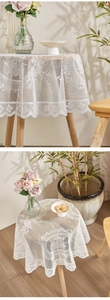Macro shot of white lace tablecloth with floral hollow patterns and scalloped edges