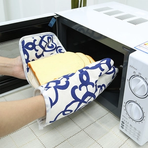 Nordic blue floral heat resistant cotton oven mitts holding a tray from a microwave