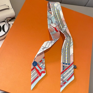 Detailed view of chain print silk scarf tied on luxury leather handbag handle