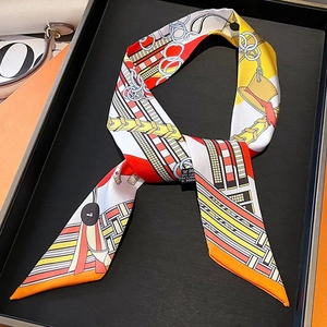Detail of a luxury chain print silk twilly scarf showing colorful geometric patterns