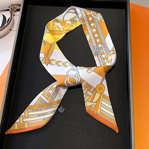 Detail of equestrian chain print silk scarf with washing label on a black display tray